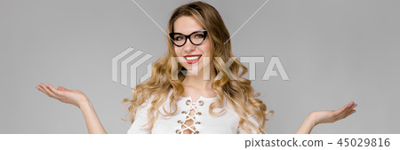 Attractive young blonde business woman in black and white clothes smiling with open hands standing 45029816