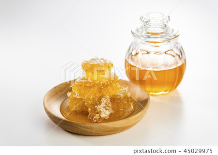 蜂蜜和蜂蜜巢進入一個小瓶子 蜂蜜和蜂蜜巢進入一個小瓶子 45029975