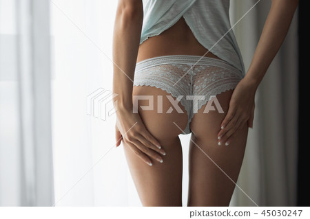 Crop woman touching buttocks 45030247