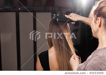 hairdresser making a gauffer hairdo of a model hairdresser making a gauffer hairdo of a model 45033009