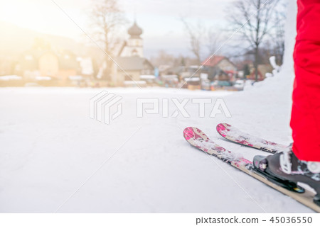 Little girl preparing to ski downhill Little girl preparing to ski downhill 45036550