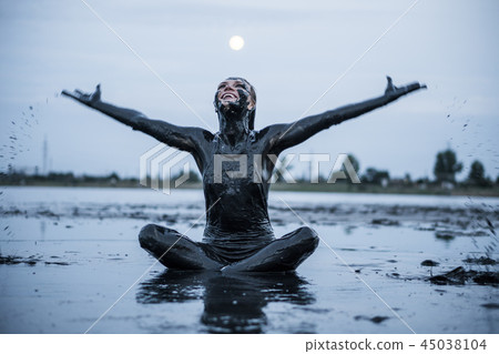 Portrait of an Adorable Caucasian Girl Sitting and posing Smeared with a Healthy Black Mud in old 45038104
