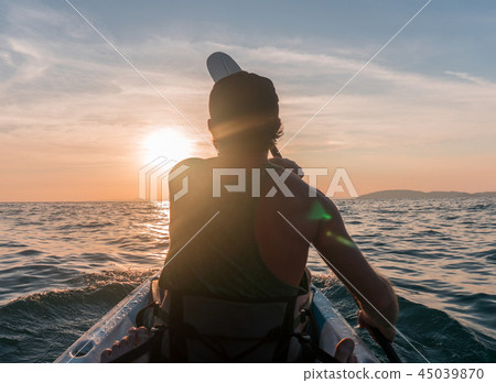 Kayaking. Man With kayak paddle at sunset sea Rowing to the Sun. Kayaking. Man With kayak paddle at sunset sea Rowing to the Sun. 45039870