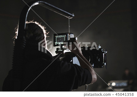 Professional videographer holding camera mounted on easy rig. Videographer using steadicam. Pro Professional videographer holding camera mounted on easy rig. Videographer using steadicam. Pro 45041358