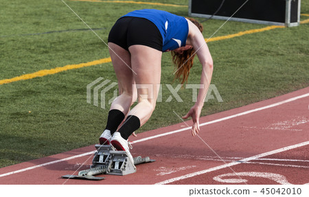 High school girl sprinter coming out of the blocks High school girl sprinter coming out of the blocks 45042010