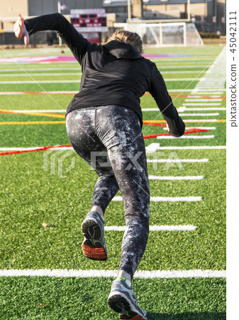 Female sprinter training on turf field Female sprinter training on turf field 45042111