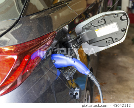 Electric powered car plugged in for charging 45042112