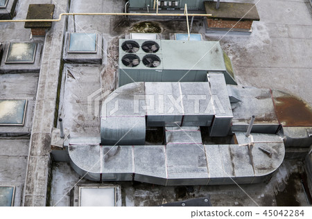 Dirty old roof of a multistory. Ventilation systems on building roof. 45042284