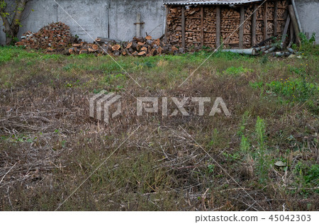 small arbor with wooden logs firewood at courtyard 45042303