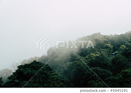A small house surrounded by mountains and fog. 45045291