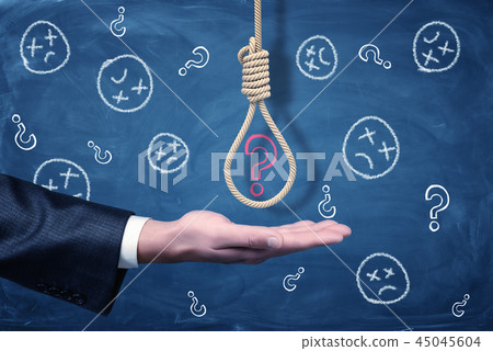 A businessman's hand with a hangman's noose above it with a red chalk question mark inside. 45045604