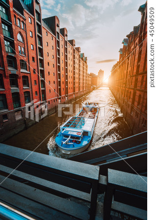 Touristic cruise boat in narrow canal of famous Speicherstadt warehouse district with red brick Touristic cruise boat in narrow canal of famous Speicherstadt warehouse district with red brick 45049509