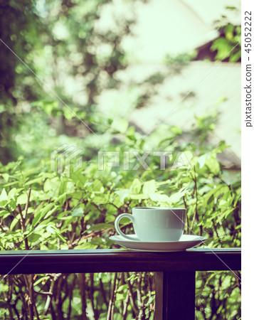 Outdoor patio with beautiful nature view and white coffee cup Outdoor patio with beautiful nature view and white coffee cup 45052222