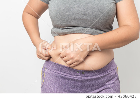 Overweight woman hand pinching excessive belly fat 45060425