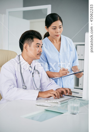 Medical workers checking data on computer 45062283