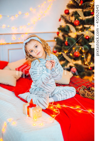 Little girl in pajamas at Christmas morning Little girl in pajamas at Christmas morning 45062645