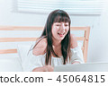 Sweet cute asian girl sitting on the bed and laughing happy using laptop computer video chat website 45064815