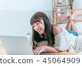 Sweet cute asian girl happy laughing in bed using laptop computer video chat website 45064909