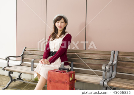 A woman sitting on a bench A woman sitting on a bench 45066825