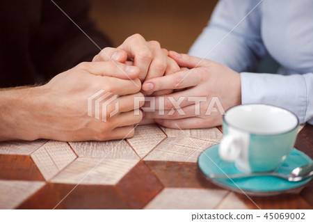 Crop loving couple holding hands at table 45069002
