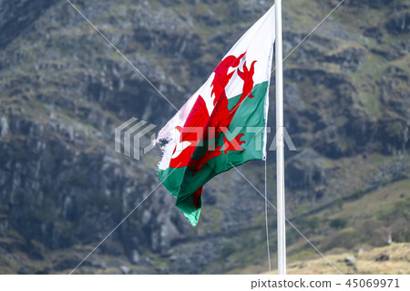 Welsh flag waving in the beautiful landscape of Llanberis, Snowdonia in Wales at the lake padarn Welsh flag waving in the beautiful landscape of Llanberis, Snowdonia in Wales at the lake padarn 45069971