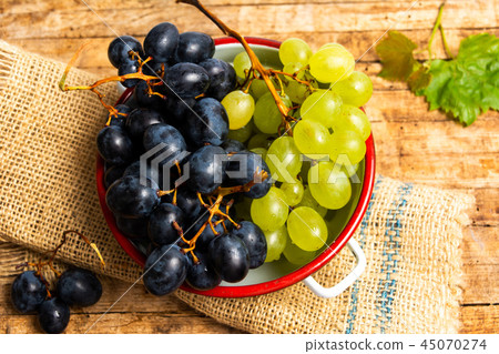 Fresh grapes in wooden background Fresh grapes in wooden background 45070274