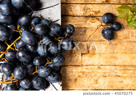 Fresh grapes in wooden background Fresh grapes in wooden background 45070275
