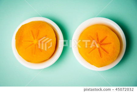 Persimmon kaki fruit on a plate top view 45072032