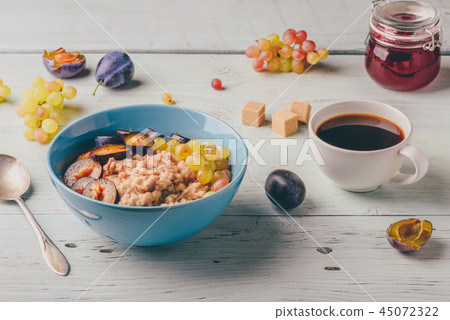 Porridge with plum, grapes and cup of coffee. 45072322