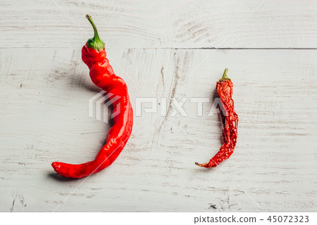Two red chili peppers, on wooden background 45072323