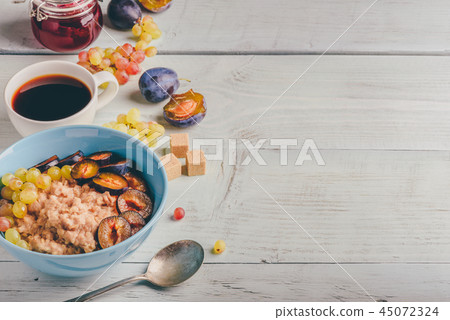 Porridge with plum, grapes and cup of coffee 45072324
