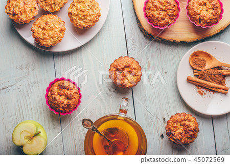 Oatmeal muffins with apple and cup of green tea 45072569