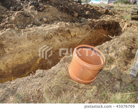 Big PVC fittings on ground at trench. Plumber tube 45076709