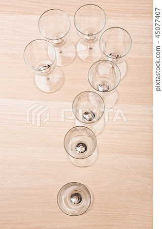 Champagne empty glass question mark wooden table Champagne empty glass question mark wooden table 45077407