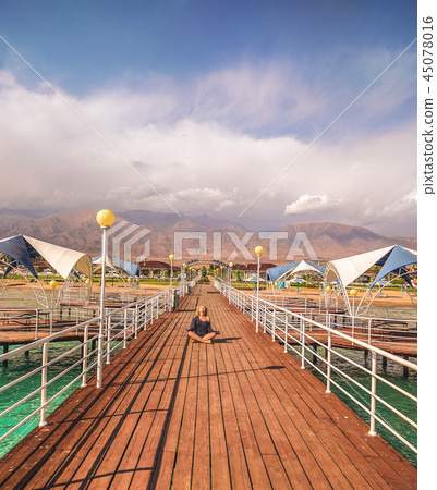 Young beautiful woman sitting back view. 45078016
