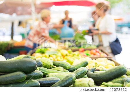 Blured unrecodnised people buying homegrown vegetable at farmers' market stall with variety of Blured unrecodnised people buying homegrown vegetable at farmers' market stall with variety of 45078212