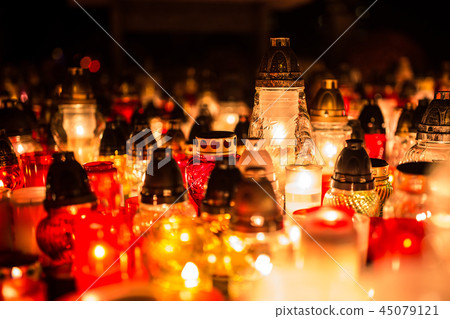 Many burning candles in the cemetery at night. 45079121