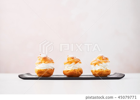 Delicious profiteroles with cream 45079771