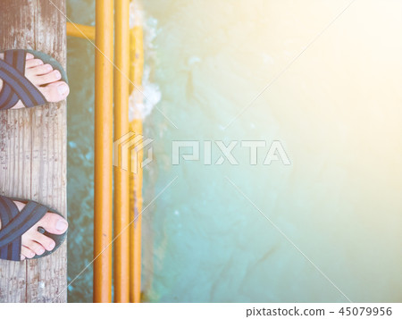 Man is on the pier in the sea. 45079956