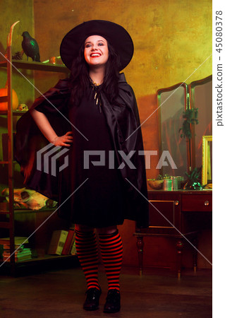 Full-length image of smiling witch in hat Full-length image of smiling witch in hat 45080378