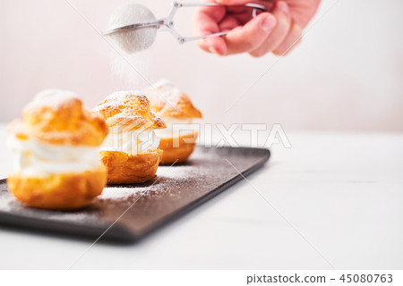 Delicious profiteroles with cream 45080763