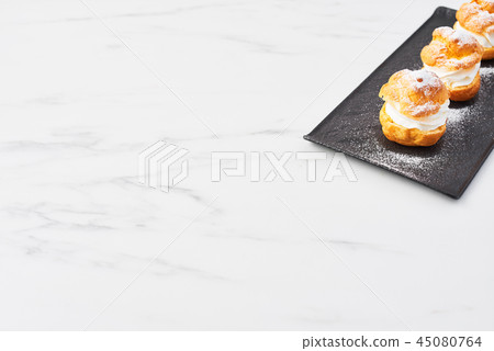 Delicious profiteroles with cream 45080764
