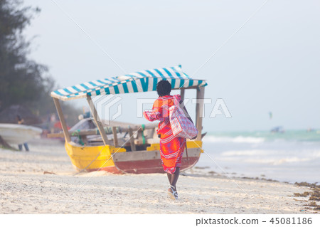 Rear view of traditonaly dressed maasai man selling hand made jewelry on picture perfect tropical Rear view of traditonaly dressed maasai man selling hand made jewelry on picture perfect tropical 45081186