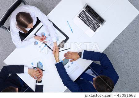 Business people shaking hands after analyzing financial documents, view from above. Business team at 45081668