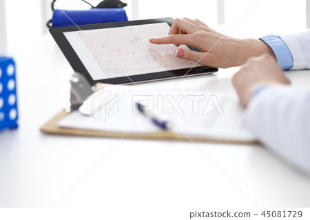 Woman doctor using tablet computer while standing straight in hospital closeup. Healthcare 45081729