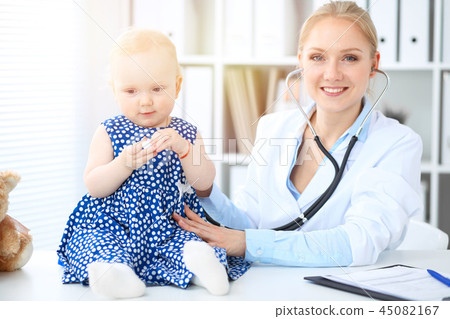 Doctor and patient in hospital. Little girl is being examined by pediatrician with stethoscope 45082167