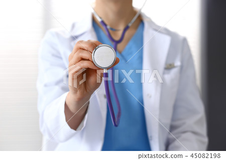 Doctor holds stethoscope head, closeup. Physician ready to examine and help patient. Medical help Doctor holds stethoscope head, closeup. Physician ready to examine and help patient. Medical help 45082198