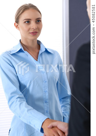 Business handshake by blonde woman and her partner at meeting. Concept of success and agreement Business handshake by blonde woman and her partner at meeting. Concept of success and agreement 45082581