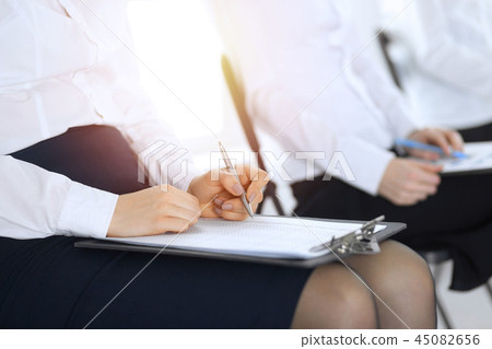 Business people taking part at conference or training at office, close-up. Women sitting on chairs Business people taking part at conference or training at office, close-up. Women sitting on chairs 45082656