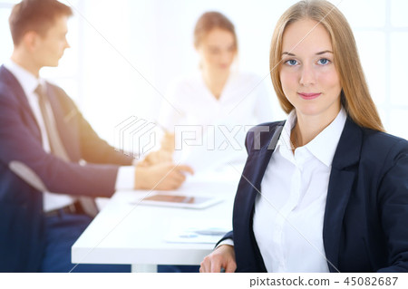 Group of business people or lawyers discussing terms of transaction in office. Focus at young 45082687
